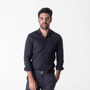 Smiling latin man posing in studio dressed in black